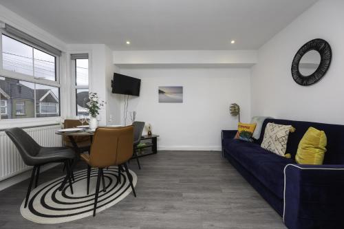 a living room with a blue couch and a table at Adelles seaside retreat in Hove
