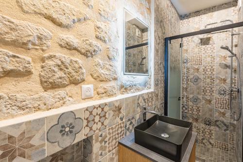 a stone bathroom with a sink and a shower at NEW Gorgeous Flat-Central Area in Paris