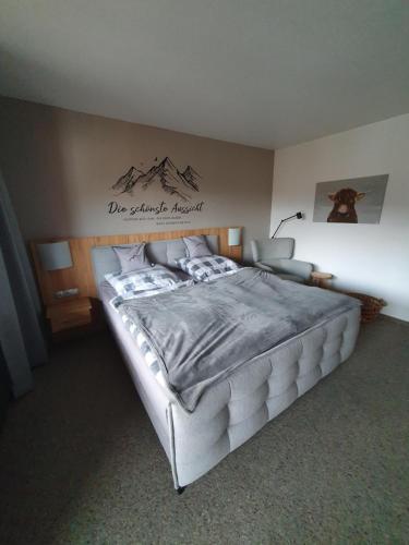 1 dormitorio con 1 cama grande y un cartel en la pared en Chiemgauer Alpenglück, en Inzell