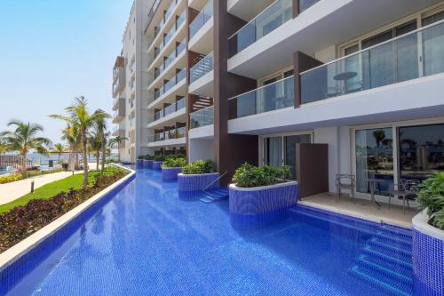a swimming pool in front of a building at Royalton Splash Riviera Cancun, An Autograph Collection All-Inclusive Resort in Cancún