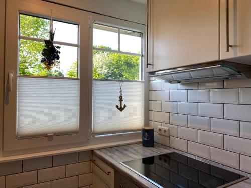 a kitchen with two windows with blinds on them at Ferienhaus Seemöwe in Damp