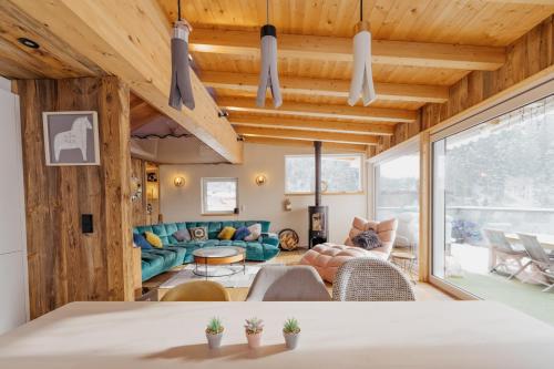 a living room with wooden ceilings and a large window at Das Mountain Getaway - Exclusive Mega Chalet Stubai Super Card in Fulpmes
