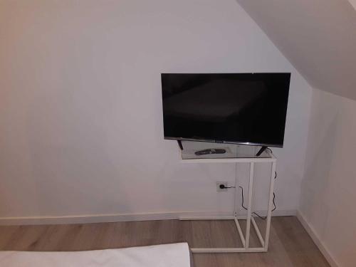 a flat screen tv sitting on a stand in a room at Tim's Guesthouse in Hannover