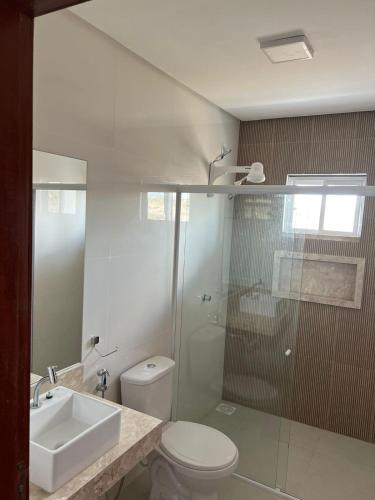 a bathroom with a toilet and a sink and a shower at Meu Chale Flecheiras in Flecheiras