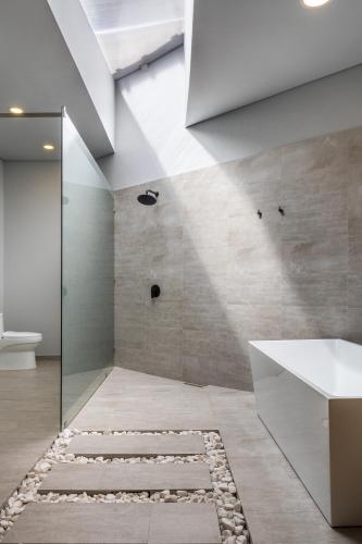 a bathroom with a walk in shower and a toilet at Tau House in Guatapé