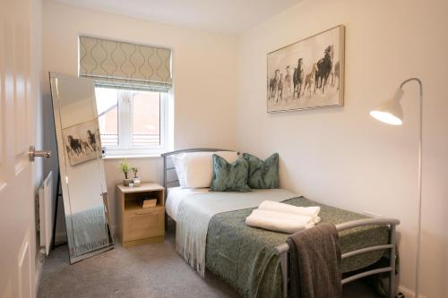 a small bedroom with a bed and a window at Jasmine House in Nottingham