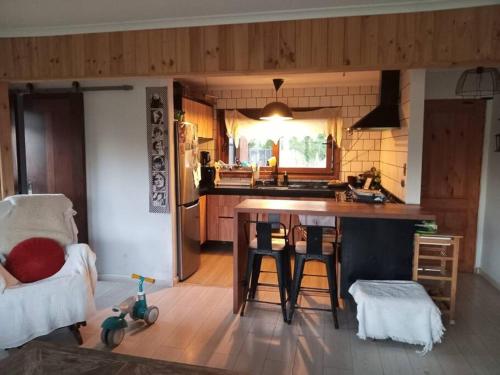 a kitchen with a table and chairs in a room at Hermosa cabaña con hot tub. in Talagante