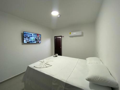 um quarto com uma cama com uma fotografia na parede em HOTEL SUEÑO REAL SM em Santa Marta