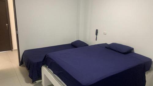 um quarto com uma cama com lençóis azuis em HOTEL SUEÑO REAL SM em Santa Marta