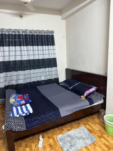 uma cama num quarto com uma cortina em Hassan Imam em Daca