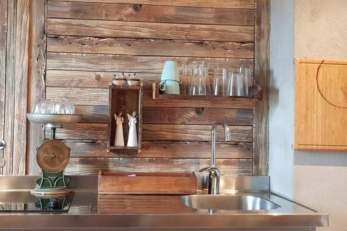 a kitchen with a sink and a wooden wall at Austefjorden Fjordsuite med Panoramautsikt in Forland