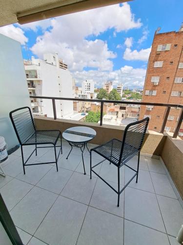 un patio con 2 sedie e un tavolo sul balcone di Departamento Entero con Pileta Calasanzs a Córdoba