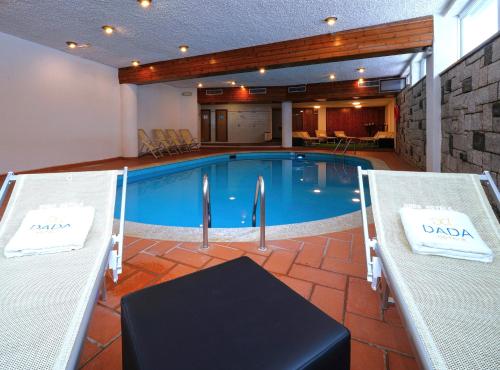 a large swimming pool with two tables and chairs at Hotel Arlecchino - Dada Hotels in Madesimo