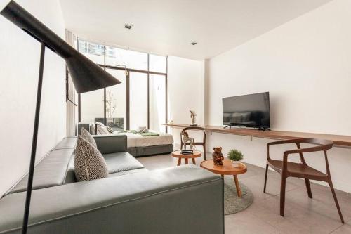a living room with a couch and a tv at MIQ_5br/Silom Bts,Mrt/Wifi 1000MB/Jacuzzi/16pax in Bangkok