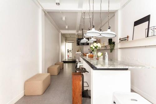 a kitchen with a counter and stools in a room at MIQ_5br/Silom Bts,Mrt/Wifi 1000MB/Jacuzzi/16pax in Bangkok