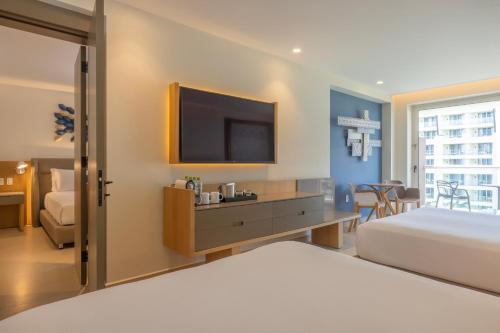 a hotel room with a bed and a flat screen tv at Royalton Splash Riviera Cancun, An Autograph Collection All-Inclusive Resort in Cancún