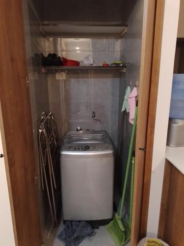 uma pequena cozinha com uma máquina de lavar roupa num quarto em Departamento acogedor y moderno em Cochabamba