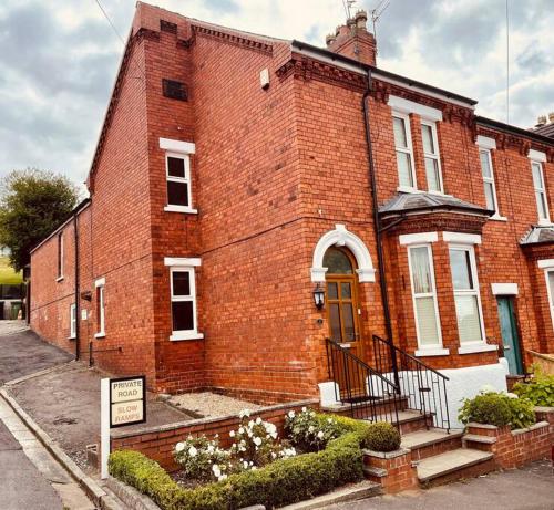 a red brick building with a sign in front of it at Close to castle + Parking for 4 Cars in Lincolnshire