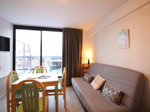 un salon avec un canapé et une table dans l'établissement Studio avec Balcon et Ascenseur - 200m du Centre - FR-1-608-137, à Le Mont-Dore