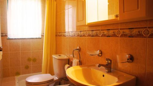 a bathroom with a sink and a toilet and a window at Casa da Igreja by Gerês Casas in Geres