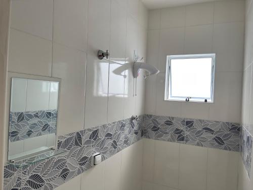 baño con lavabo, espejo y ventana en Casa nova e móveis novos en Caraguatatuba