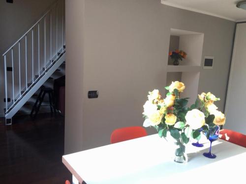 a vase of flowers on a table with two red chairs at ITD unione in Milan