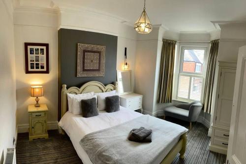 a bedroom with a large white bed and a chair at Close to castle + Parking for 4 Cars in Lincolnshire