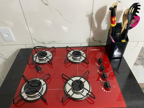 a red stove with four burners on a counter at SUA CASA EM GARANHUNS Aptº INTEIRO COM 04 QUARTOS in Garanhuns