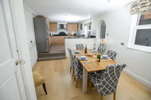 a dining room with a table and chairs and a kitchen at Close to castle + Parking for 4 Cars in Lincolnshire