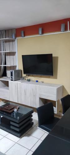 uma sala de estar com uma televisão de ecrã plano na parede em C & B APARTAMENTOS em Jauja