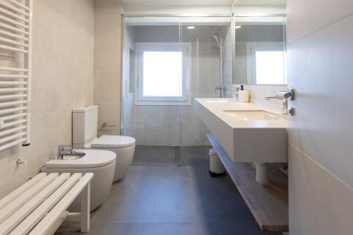 a bathroom with a toilet and a sink and a shower at Suitur beachfront apartment Roc de Sant Gaietà in Roda de Bará
