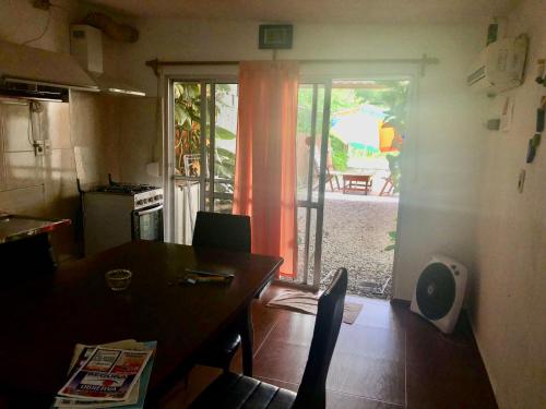 cocina con mesa y puerta a un patio en Casa en Atlántida, Barrio Español, Uruguay en Villa Argentina