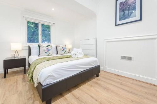 a white bedroom with a bed and a window at 2 Bed Piccadilly Apartment- 4 in London