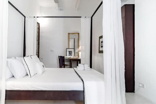 una camera con letto bianco e specchio di Authentic Seafront Experience a Sliema