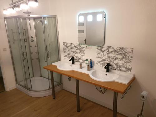 a bathroom with two sinks and a shower at City Pension Spremberg in Spremberg