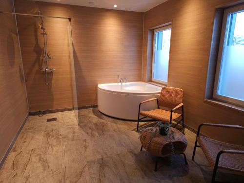 a bathroom with a tub and a chair and a table at Hotellet i Jörn AB in Jörn