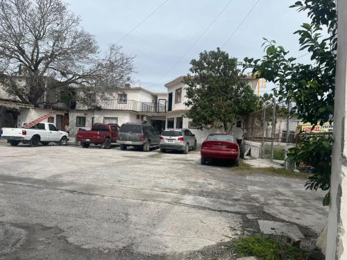 a parking lot with cars parked in front of a house at LOSSANTOS in Matamoros
