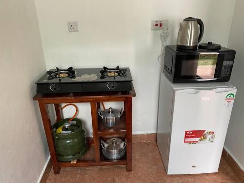 a kitchen with a stove and a microwave and a refrigerator at Cynthia’s Homestays@0723632635 in Malindi