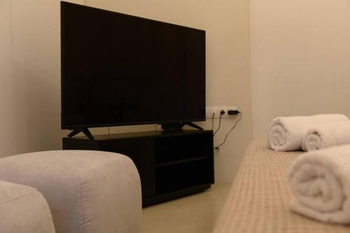 San Rocco Suite في Ágios Rókkos: غرفة معيشة مع تلفزيون بشاشة مسطحة على منصة