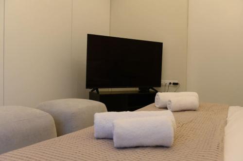 San Rocco Suite في Ágios Rókkos: غرفة نوم مع تلفزيون بشاشة مسطحة ومنشفتين