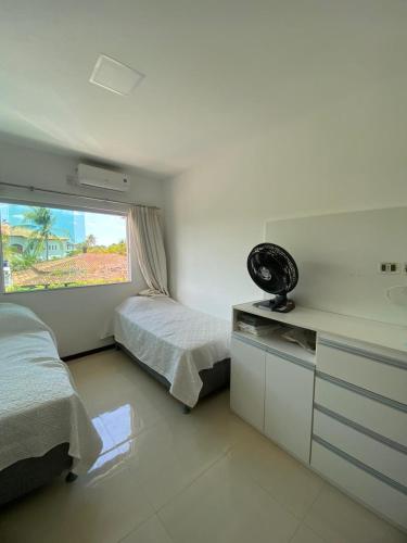 een slaapkamer met 2 bedden en een raam bij Casa Recanto de Guarajuba in Camassari
