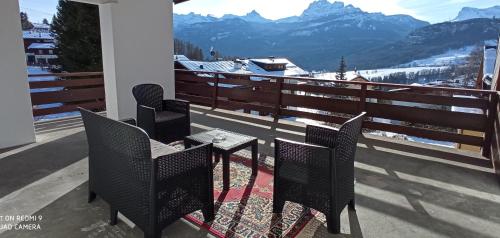 a table and chairs on a balcony with mountains at Panorama mozzafiato in Cortina dʼAmpezzo