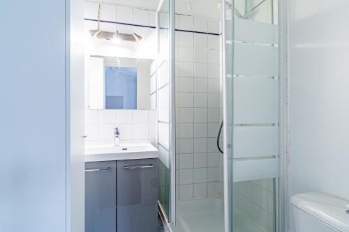ein Bad mit einer Glasdusche und einem Waschbecken in der Unterkunft Flat next to Montparnasse train station in Paris