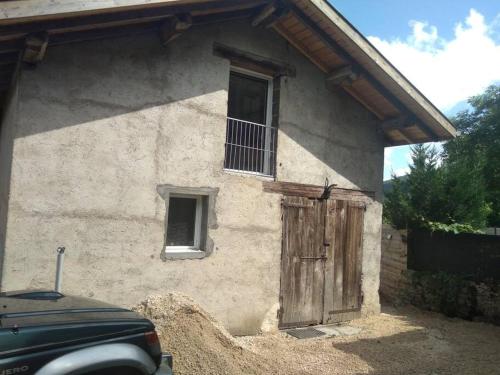 ein Gebäude mit einer Holztür und einem Fenster in der Unterkunft Le gîte du Grangeon Bugiste à Argis 