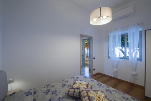 a white bedroom with a bed and a lamp at Casa Giuseppina in Furore