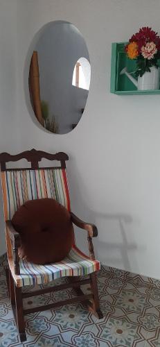 a chair sitting in a room with a mirror at Bonita Casa Señorial en pleno casco antiguo de Nijar in Níjar