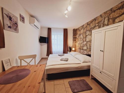 a small bedroom with a bed and a wooden floor at Balaton Apartman Füred in Balatonfüred