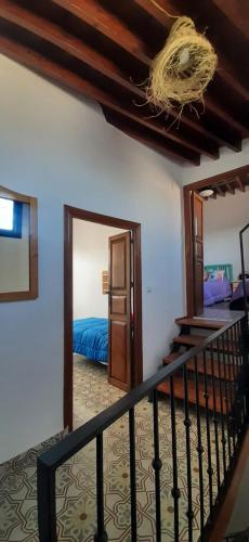尼哈尔Bonita Casa Señorial en pleno casco antiguo de Nijar的一间设有楼梯的客房,通往一间卧室