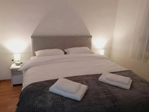 a large white bed with two white towels on it at Apartman STAR in Široki Brijeg