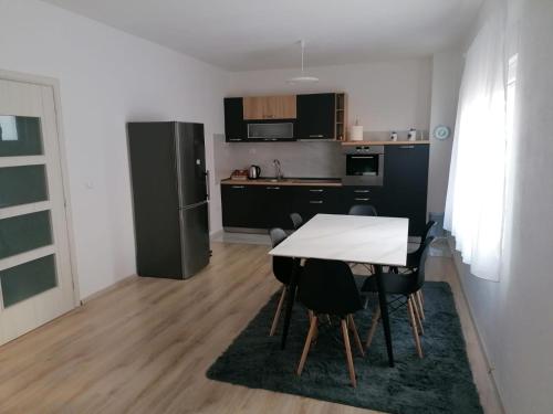 a kitchen with a white table and black appliances at Apartman STAR in Široki Brijeg